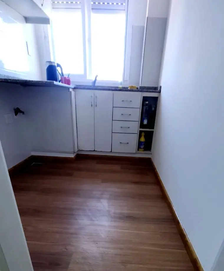 Cocina con piso vinílico símil madera colocado sobre el piso existente, con zócalos nuevos