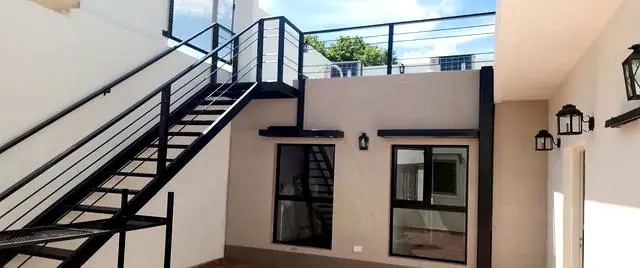Escalera metálica y frente interno con faroles y ventanas nuevas