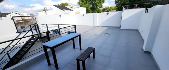Terraza transitable con porcelanato, baranda metálica y mesa