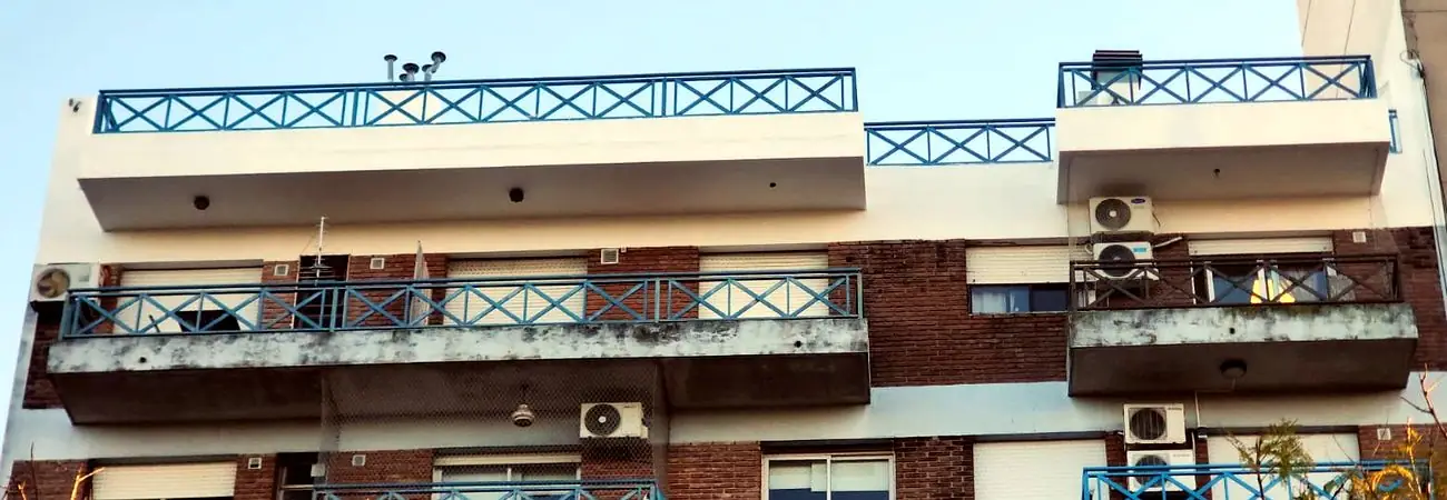 Últimos pisos de un edificio con frente pintado y balcones en reparación
