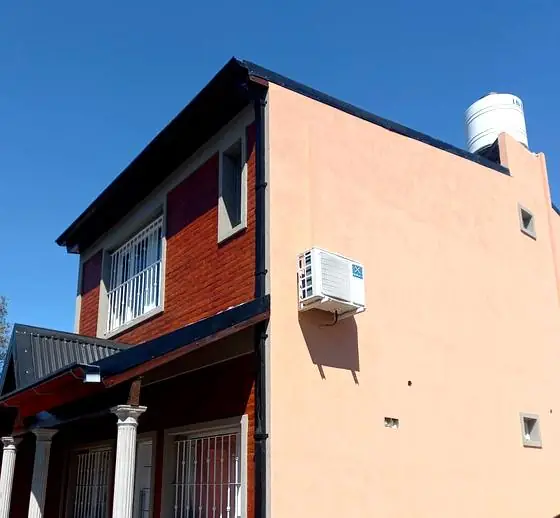 Vivienda de dos plantas con medianera revocada y frente de ladrillo visto